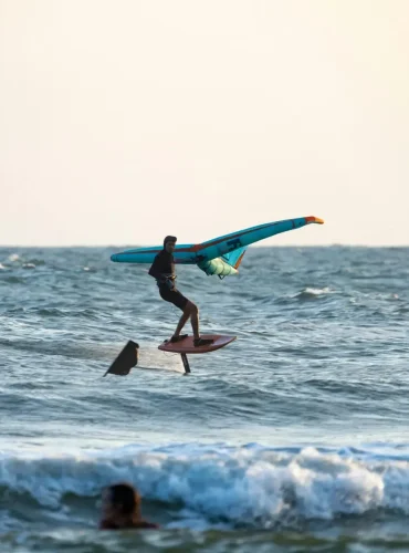 Exciting wingfoiling experience on ocean waves with active surfers enjoying the sport.